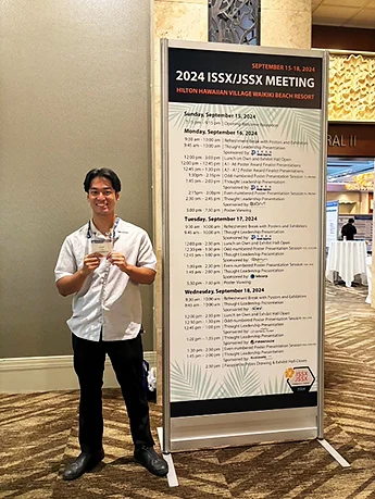 「2024 ISSX/JSSX MEETING」のスケジュール表と共に著者が写っている写真